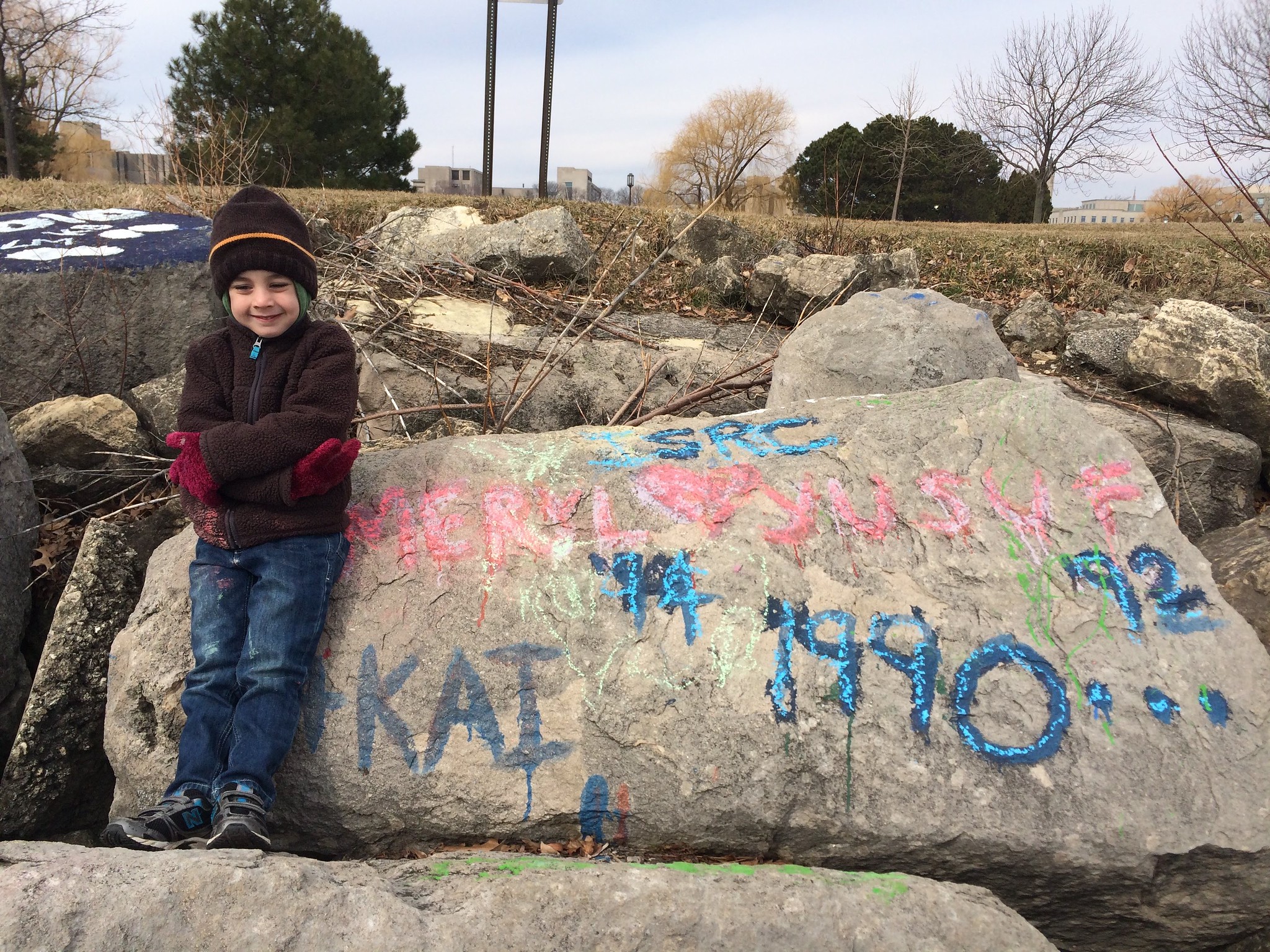 Our son leaning against the Rock in winter, beside the same names.